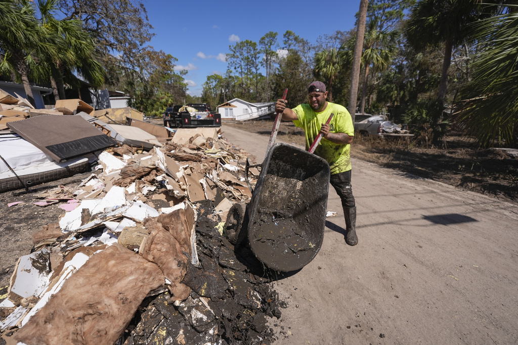 Jose Salazar dumps debris as he helps gut a property that took on a storm surge in the aftermath of Hurricane Helene, in Steinhatchee, Fla., Sunday, Sept. 29, 2024. (AP Photo/Gerald Herbert)