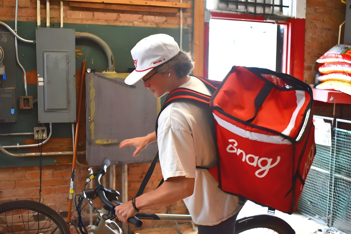 Snag delivery driver getting ready to deliver on an e-bike, photo courtesy of https://snagdelivery.app/