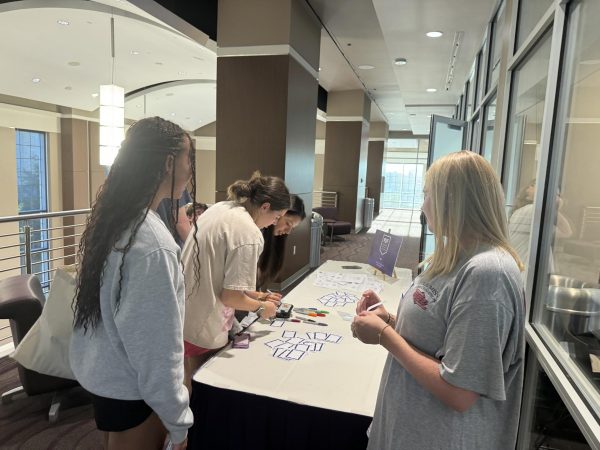 Members greet each other and write name tags in preparation for worship night.