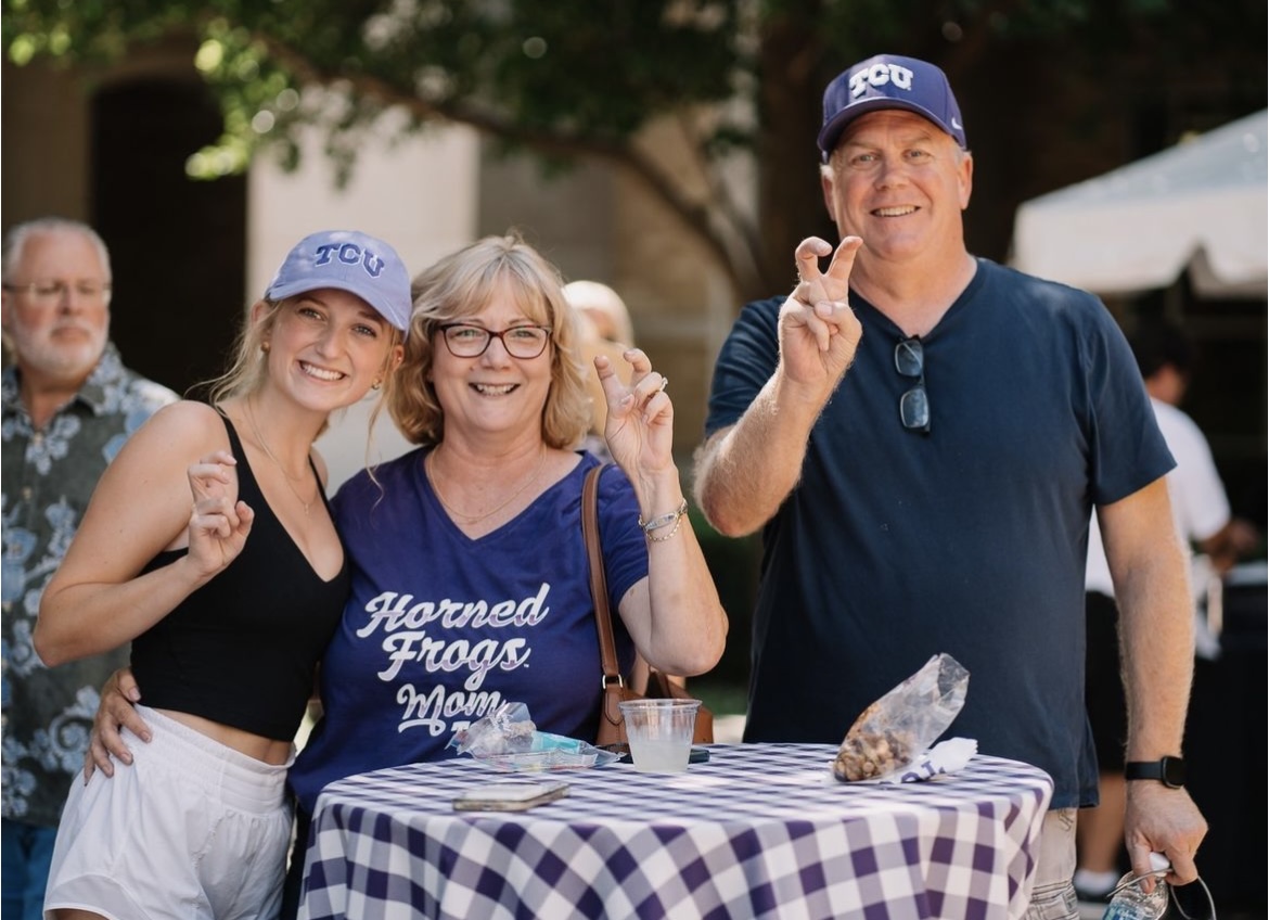 A TCU student and her family throw up a "Go Frogs" during the TCU Family tailgate at last years Parents Weekend.
