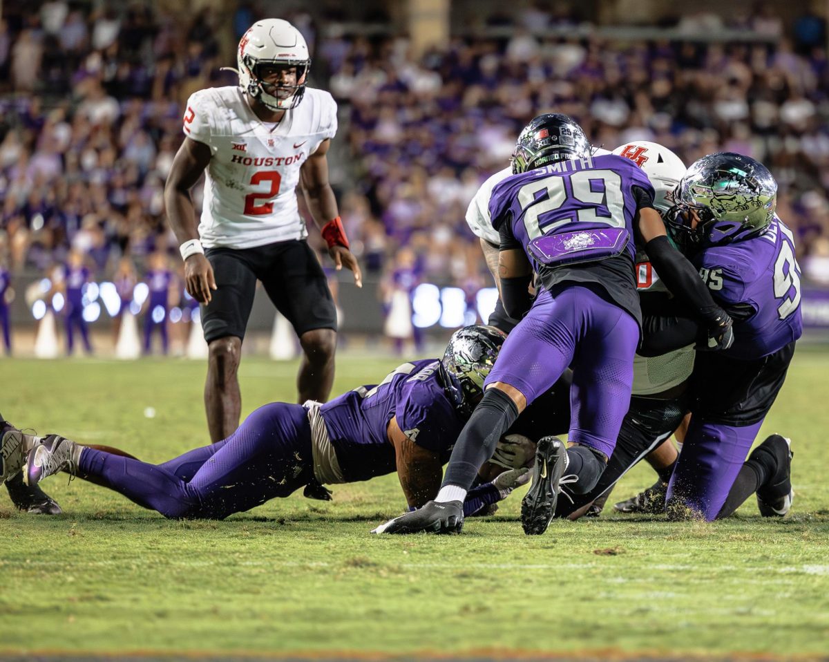 TCU players Cam Smith, Namdi Obiazor and Markis Deal tackle the opposing player at Amon G. Carter Stadium in Fort Worth, Texas on October 4th, 2024. The TCU Horned Frogs fell to the Houston Cougars 19-31 (TCU360/Tyler Chan)