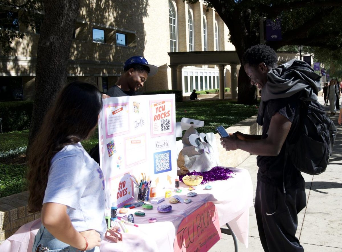 A prospective TCU Rocks member stopped by tabling to scan the GroupMe code. (Perrin Gilman)
