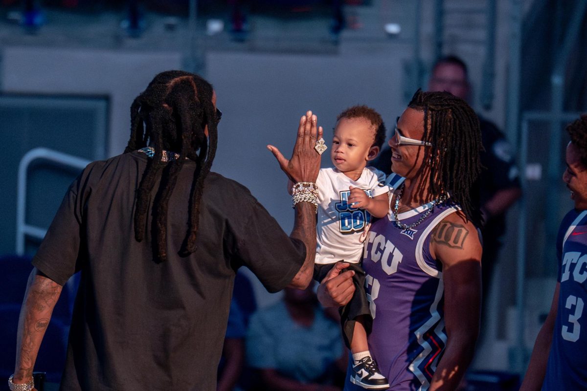 Trazarien White and a child greet 2 Chainz during Schollmaier Live, Oct. 25, 2024.