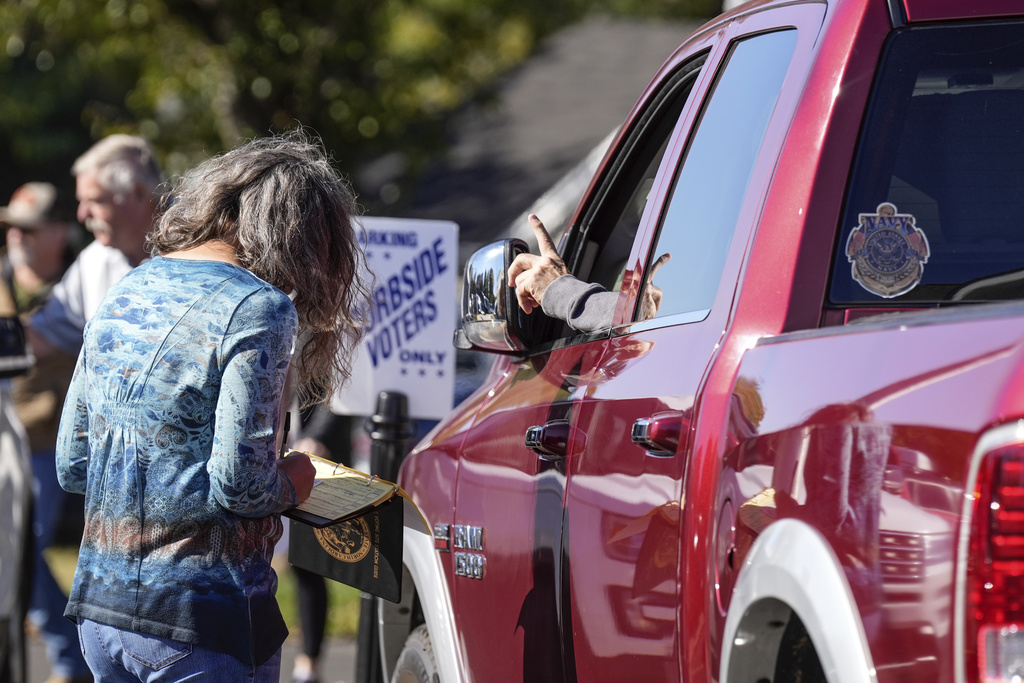 Jennifer Schmidt, a poll worker, helps a voter with curbside voting outside the Rutherford County Annex Building on the first day of early voting, Thursday, Oct. 17, 2024 in Rutherfordton, N.C. (AP Photo/Kathy Kmonicek)