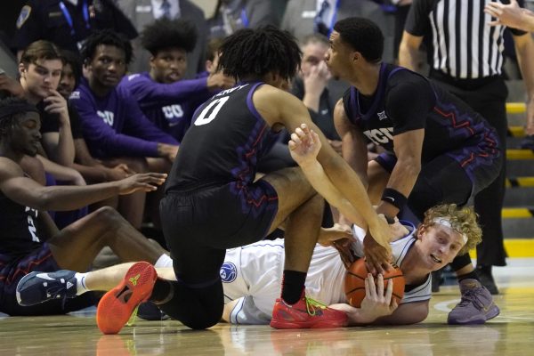 BYU guard Richie Saunders, bottom right, fights for the ball with TCU guard Micah Peavy (0) and TCU guard Jameer Nelson Jr., right, during the second half of an NCAA college basketball game Saturday, March 2, 2024, in Provo, Utah. (AP Photo/George Frey)