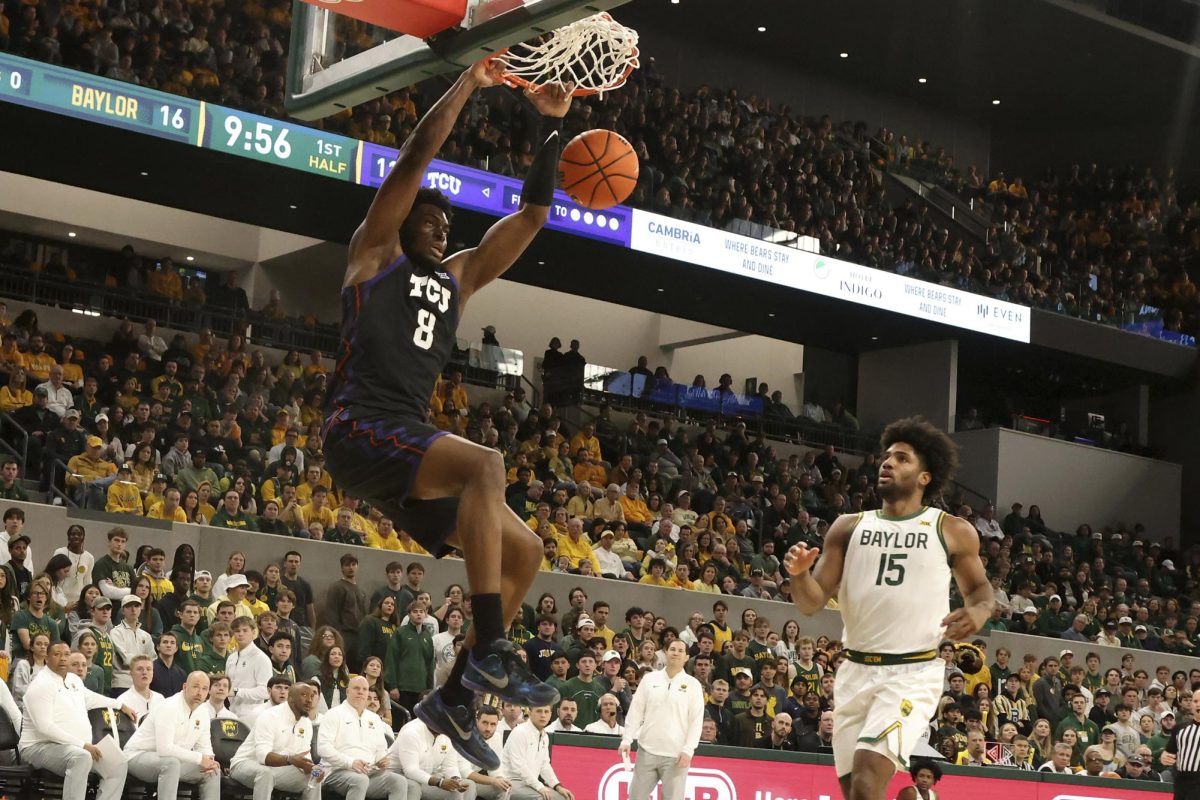 TCU center Ernest Udeh Jr. (8) dunks as Baylor forward Norchad Omier (15) watches during the first half of an NCAA college basketball game Sunday, Jan. 19, 2025, in Waco, Texas. (AP Photo/Jerry Larson)