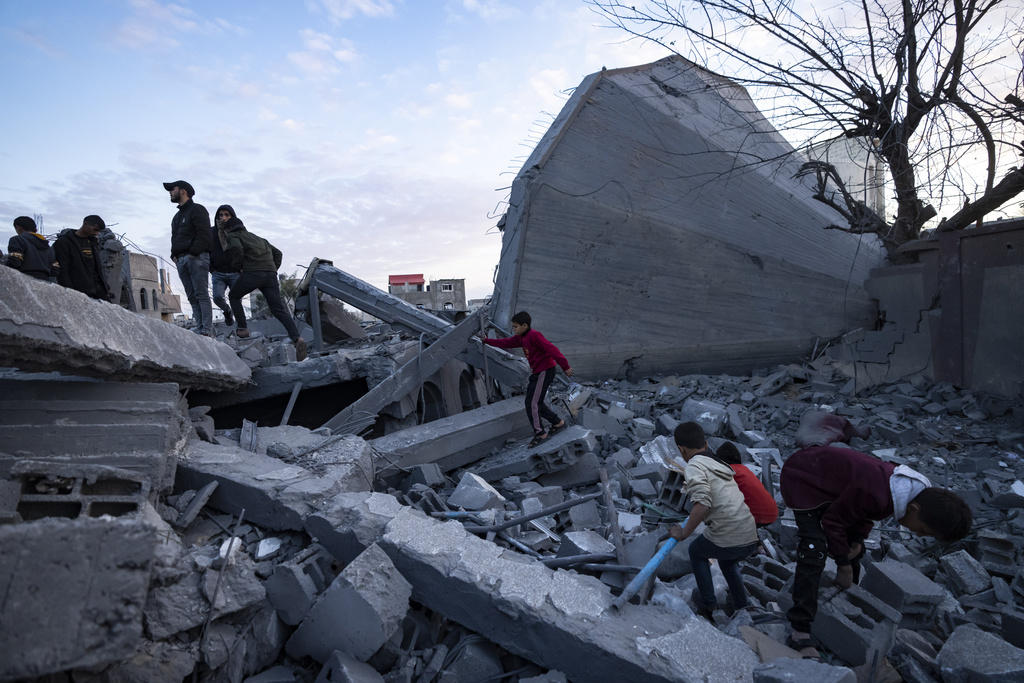 Palestinians look at a mosque destroyed in an Israeli strike in Rafah, Gaza Strip, Wednesday, Jan. 24, 2024. Efforts to reach a new cease-fire between Israel and Hamas appear to be gaining steam. Any deal would have to include a pause in fighting, an exchange of hostages held by Hamas for Palestinian prisoners held by Israel and large quantities of desperately needed humanitarian assistance for the war-battered Gaza Strip. But finding a formula acceptable to both sides has been elusive. The gaps between Israel and Hamas remain wide, and the chances of an agreement anytime soon still appear to be slim. (AP Photo/Fatima Shbair)