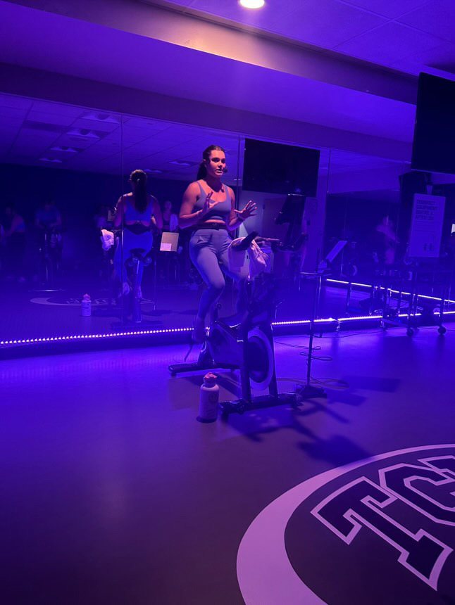 TCU student instructor Riley Richards teaching her cycle class at the recreation center.