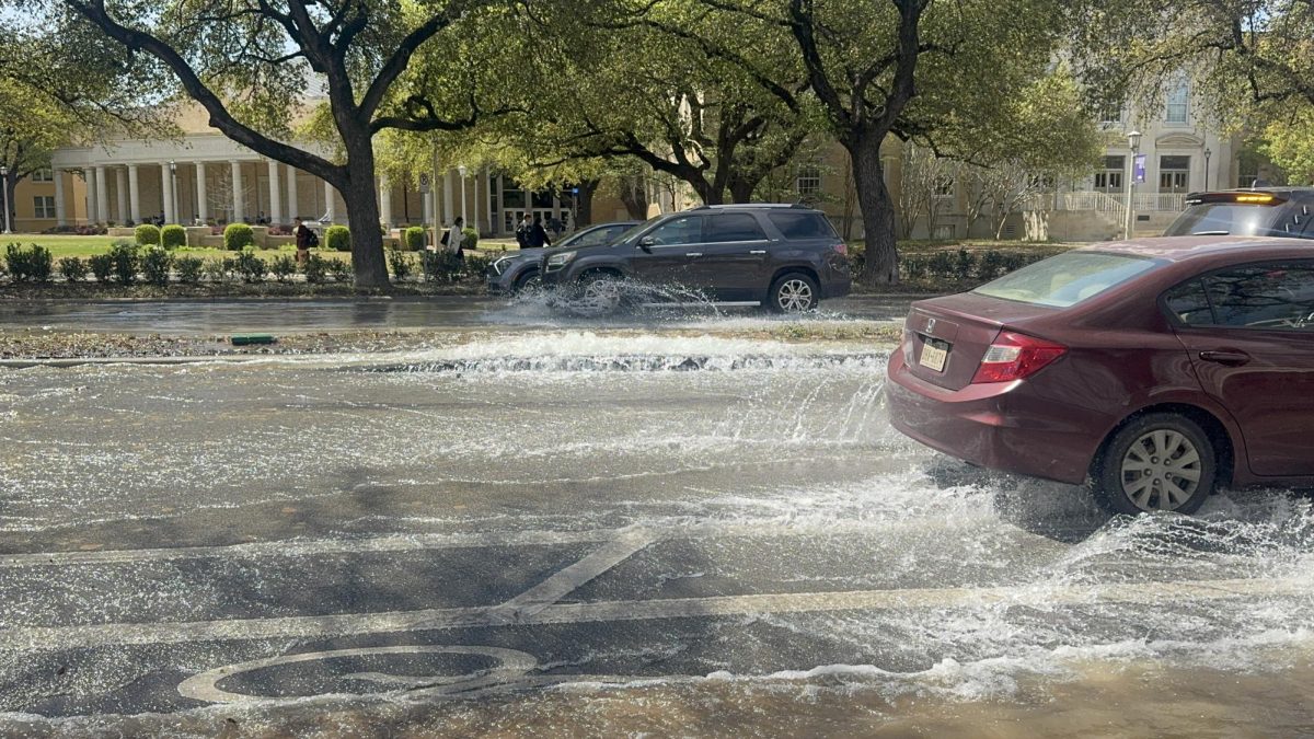 Cars driving through water main break