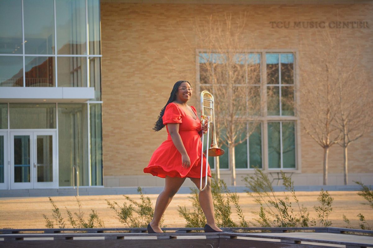 Jessica Rowe, a graduating senior in music education posing in front of the TCU Music Center for her senior photos. (Krystal Guerra/Staff Writer)