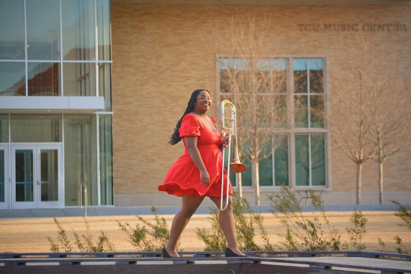 Jessica Rowe, a graduating senior in music education posing in front of the TCU Music Center for her senior photos. (Krystal Guerra/Staff Writer)