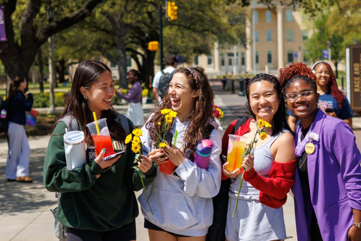 Students hold yellow daisies distributed by Student Body Vice President Charity Ketu's campaign team Monday, April 7, 2025.