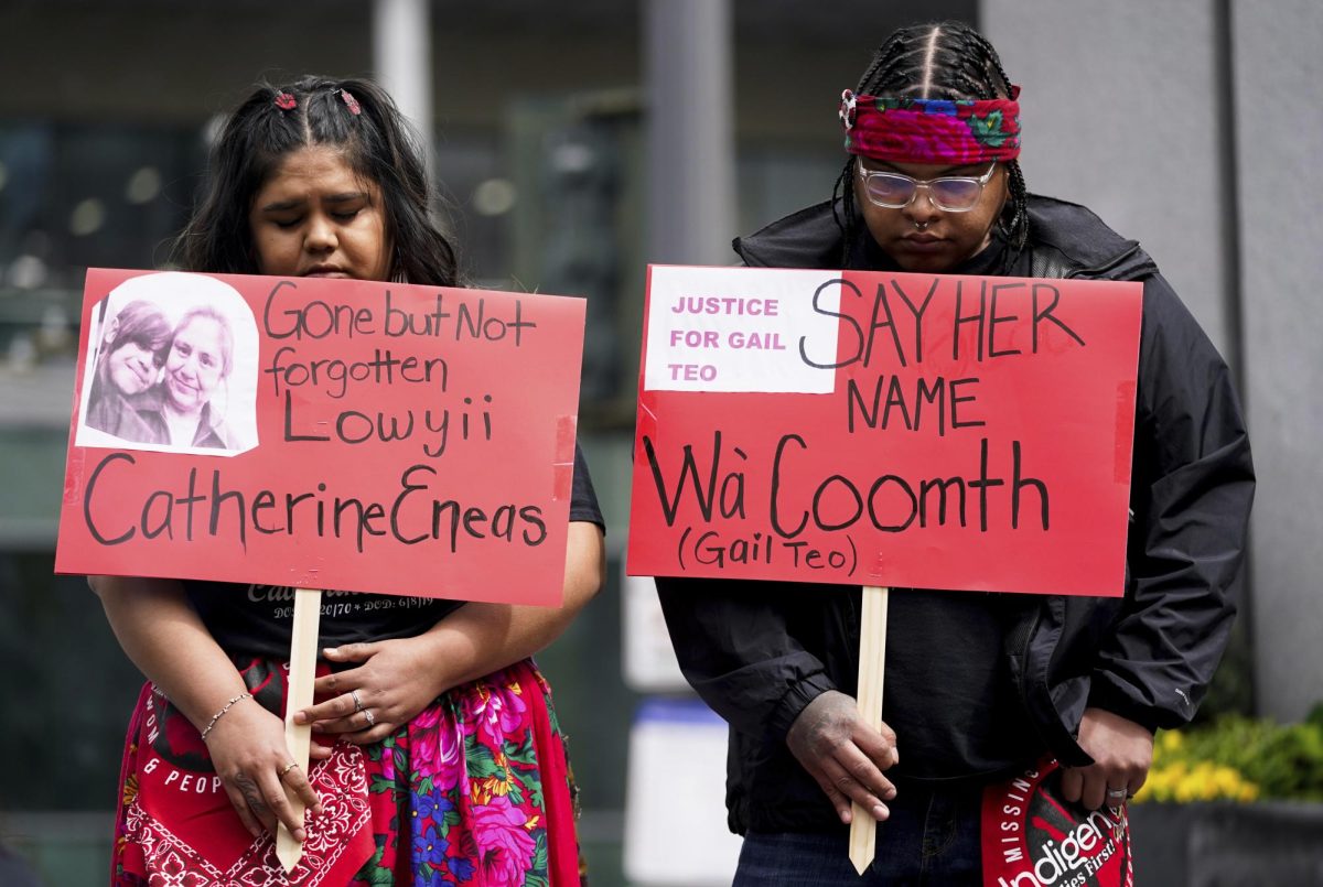 Ella Adams, left, holds a sign in memory of her mother, Catherine Eneas, as Dominic Whalawitsa holds a sign for his aunt Gail Teo during the third annual march and gathering for Missing & Murdered Indigenous Women, People & Families, hosted by the grassroots organization MMIWP Families, Saturday, May 6, 2023, in Seattle. Both Eneas and Teo were killed in 2019 and were members of the Yakama Nation. (AP Photo/Lindsey Wasson)