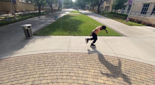 TCU facilities employee Wesley McCoy rollerskating on campus.