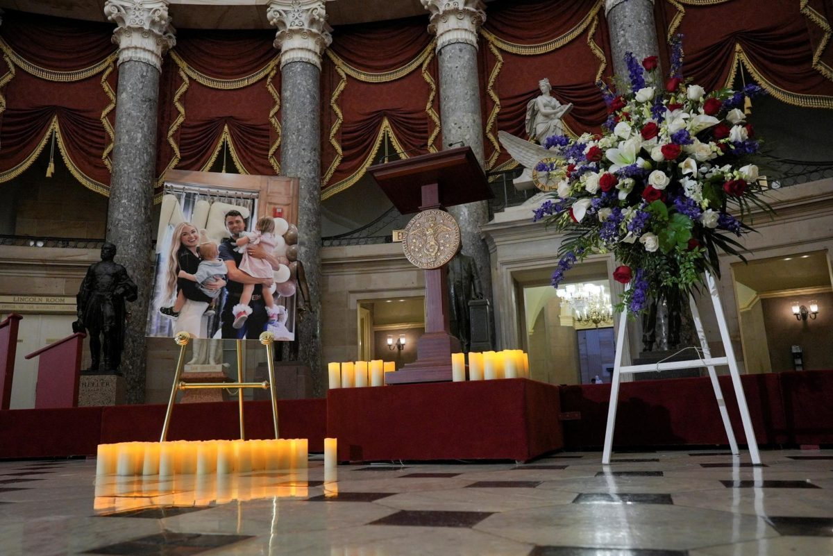 Candles and flowers are placed near an image of conservative activist Charlie Kirk with his family, during a vigil for him in Statuary Hall of the U.S. Capitol in Washington, D.C., U.S., September 15, 2025. REUTERS/Ken Cedeno