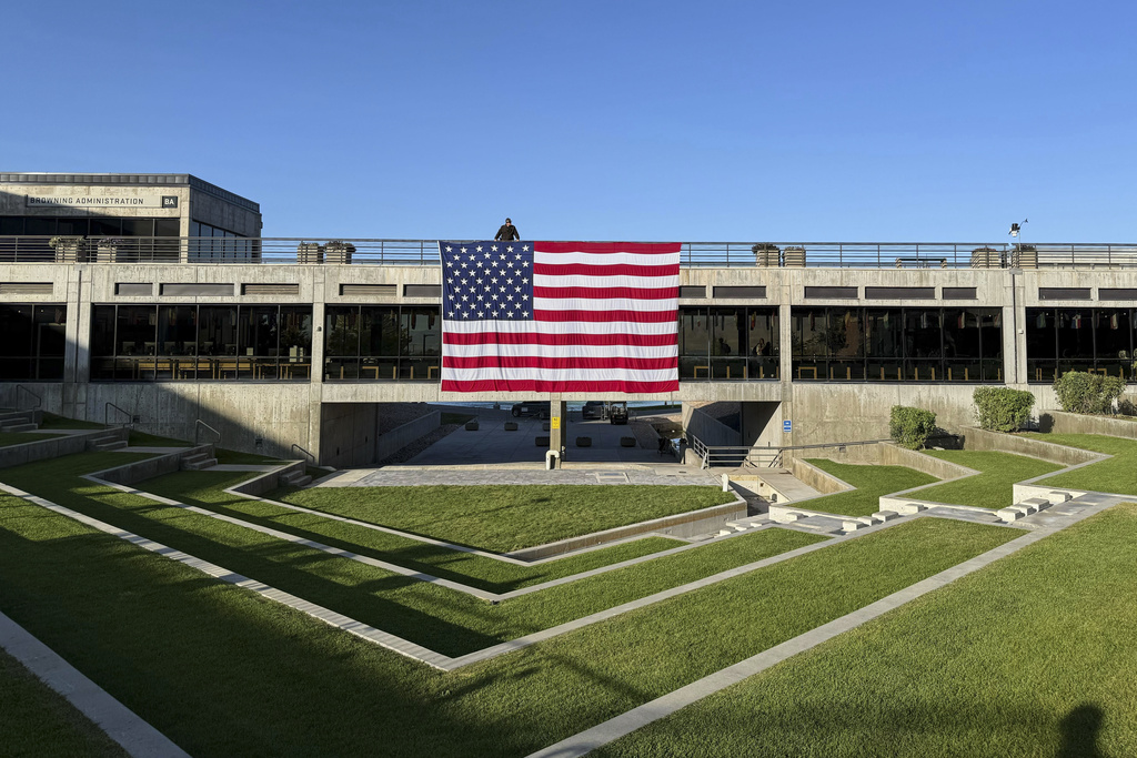 A national flag hangs over the site where conservative activist Charlie Kirk was shot and killed at Utah Valley University last week, Wednesday, Sept. 17, 2025, in Orem, Utah. (AP Photo/Jesse Bedayn)