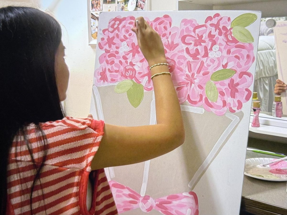 Leni Nguyen paints a big-little reveal poster for a client. 