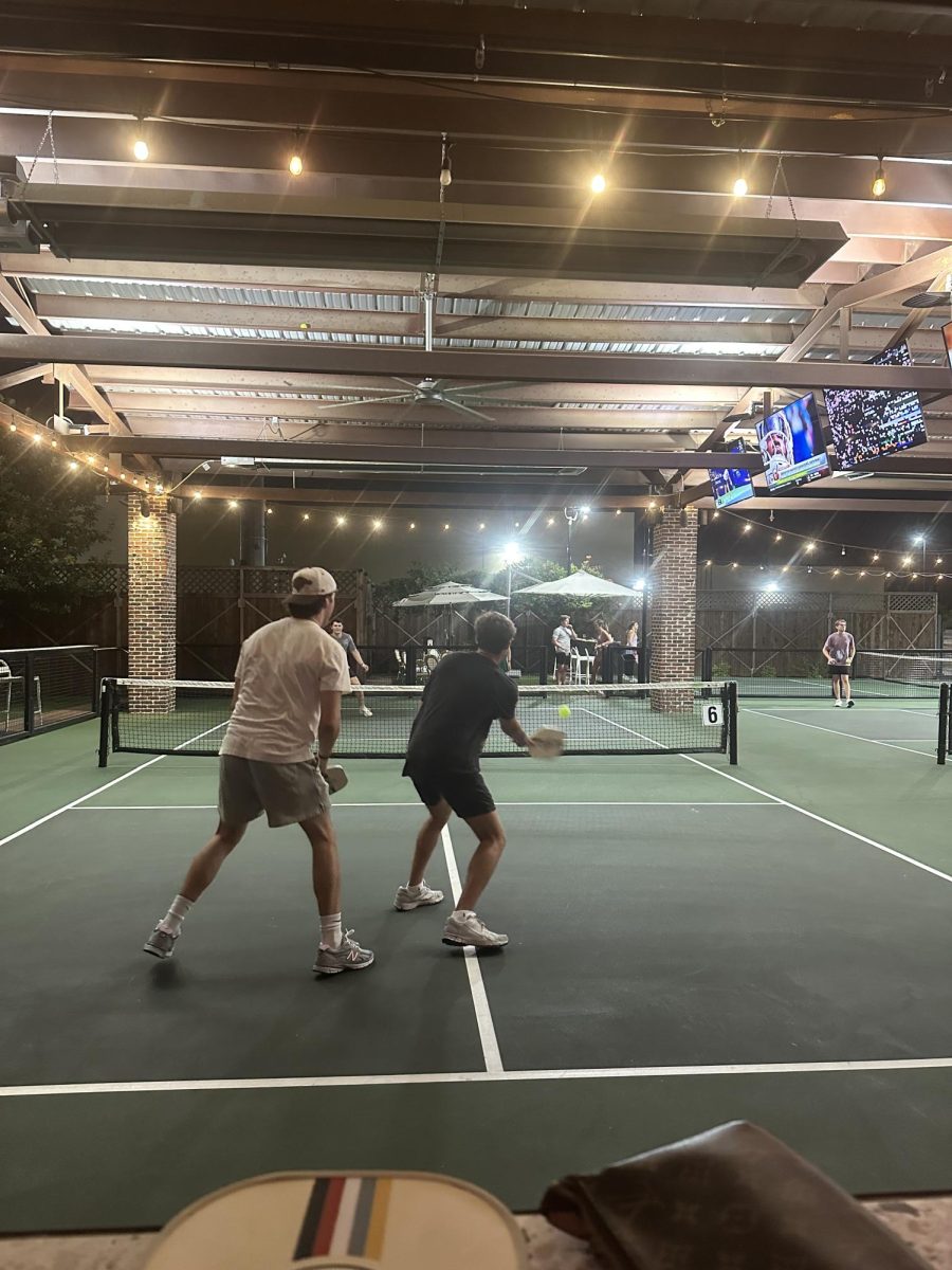 College students play pickleball on a Wednesday night at Courtside Kitchen. The venue provides free equipment and  court access to students with valid IDs.