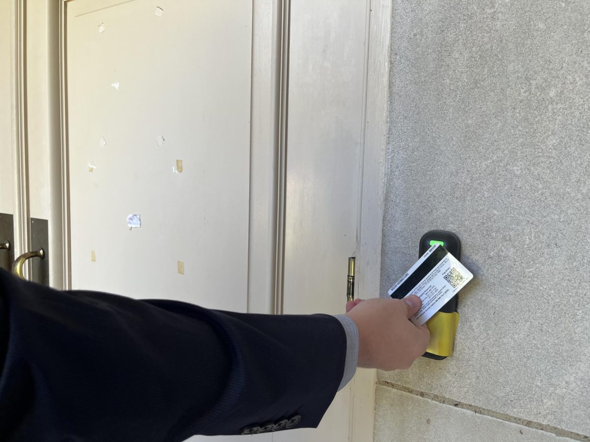 A student uses the new tap ID card. Many buildings already have the new scanners making it difficult for majors to access their classrooms and materials after hours.