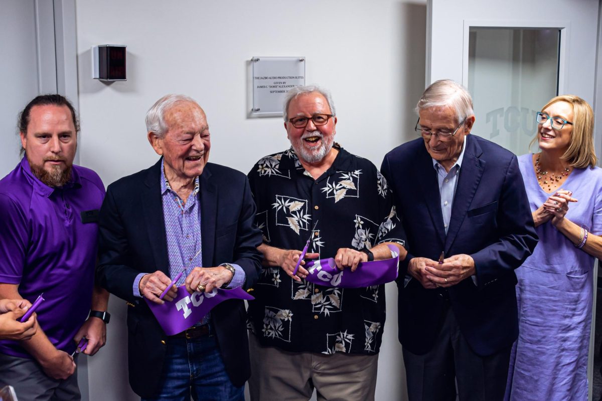 Geoffry Craig, KTCU station manager; Bob Schieffer; Jamie Alexander, KTCU donor; Roy Eaton, Roxo donor; and Janice McCall, KTCU station manager, cutting the purple TCU ribbon at the grand opening of the newly renovated KTCU radio station.
