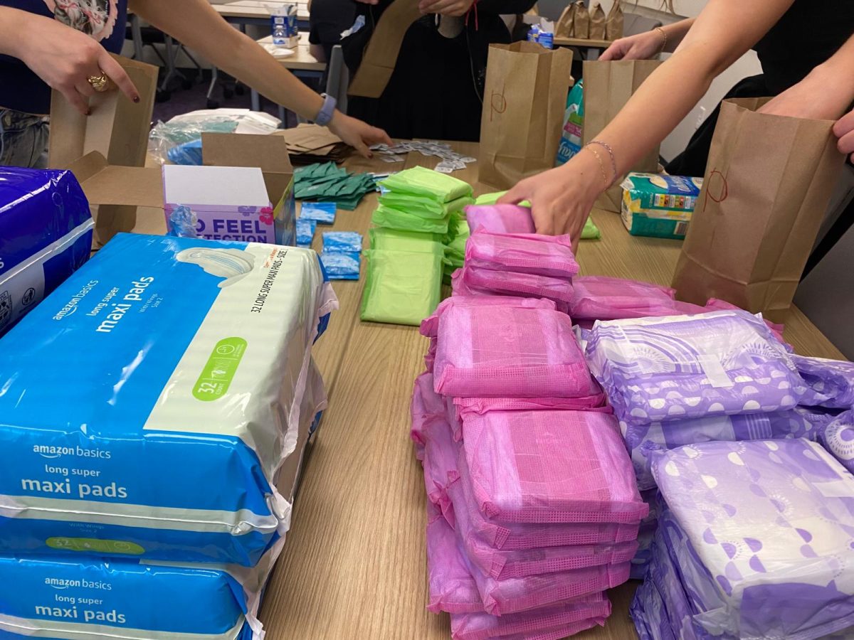 Students sorting menstrual products into care packages during a period kit packing party. (Miroslava Lem Quinonez/Staff Writer)