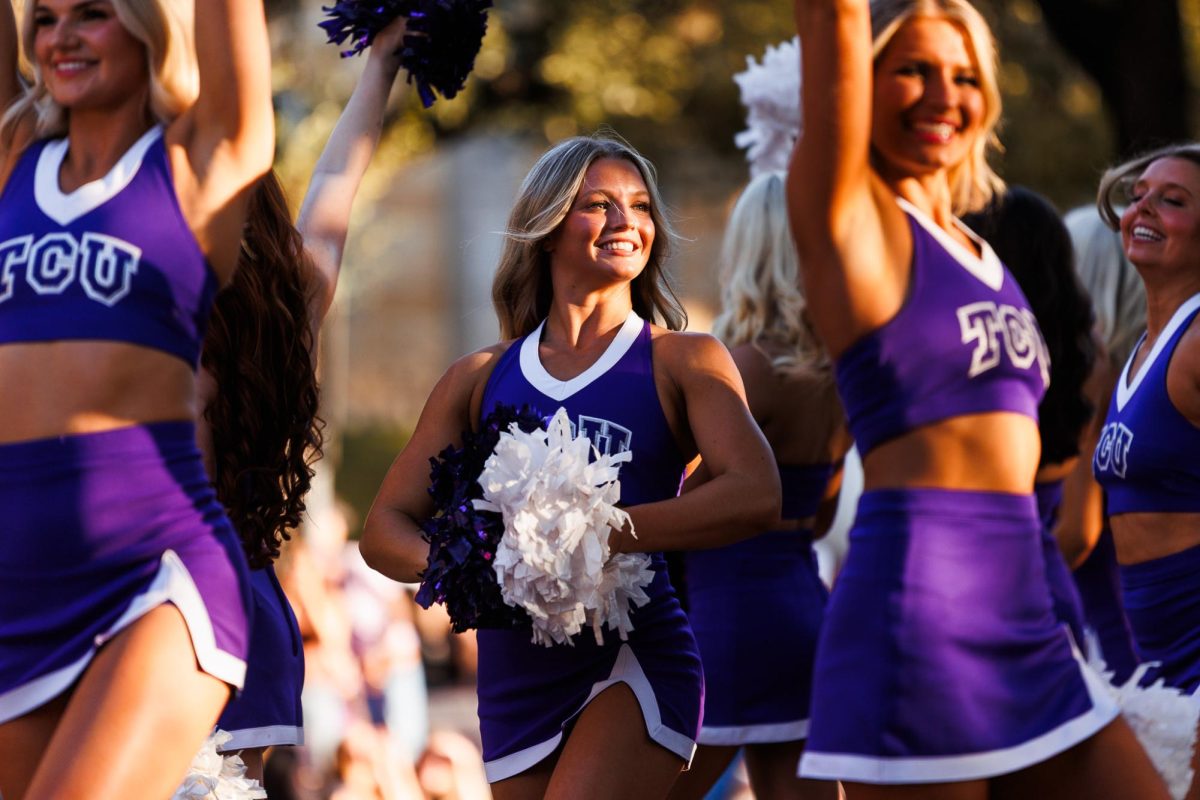 A TCU cheerleader smiles toward the crowd at the homecoming parade in Fort Worth, Texas Oct. 17, 2025.