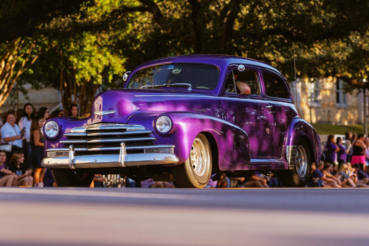 A purple car driving down Stadium Drive the TCU homecoming parade in Fort Worth, Texas Oct. 17, 2025. (TCU360/ Tyler Chan)