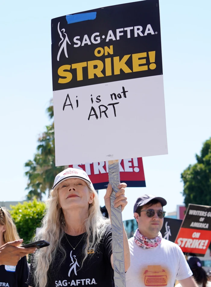 Actor Frances Fisher holds a sign that says “AI is not art.”