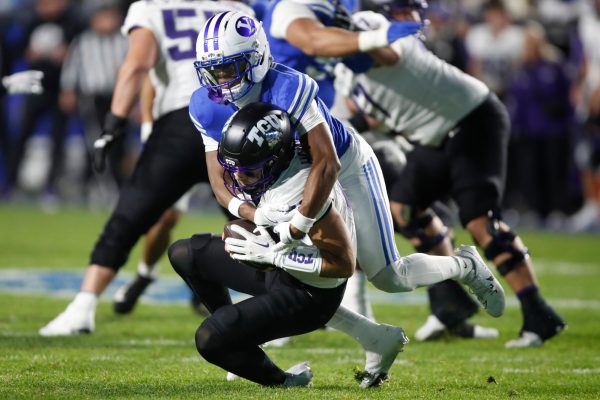 BYU defensive back Evan Johnson, right, sacks TCU quarterback Josh Hoover (10) during the second half of an NCAA college football game, Saturday, Nov. 15, 2025, in Provo, Utah. (AP Photo/George Frey)
