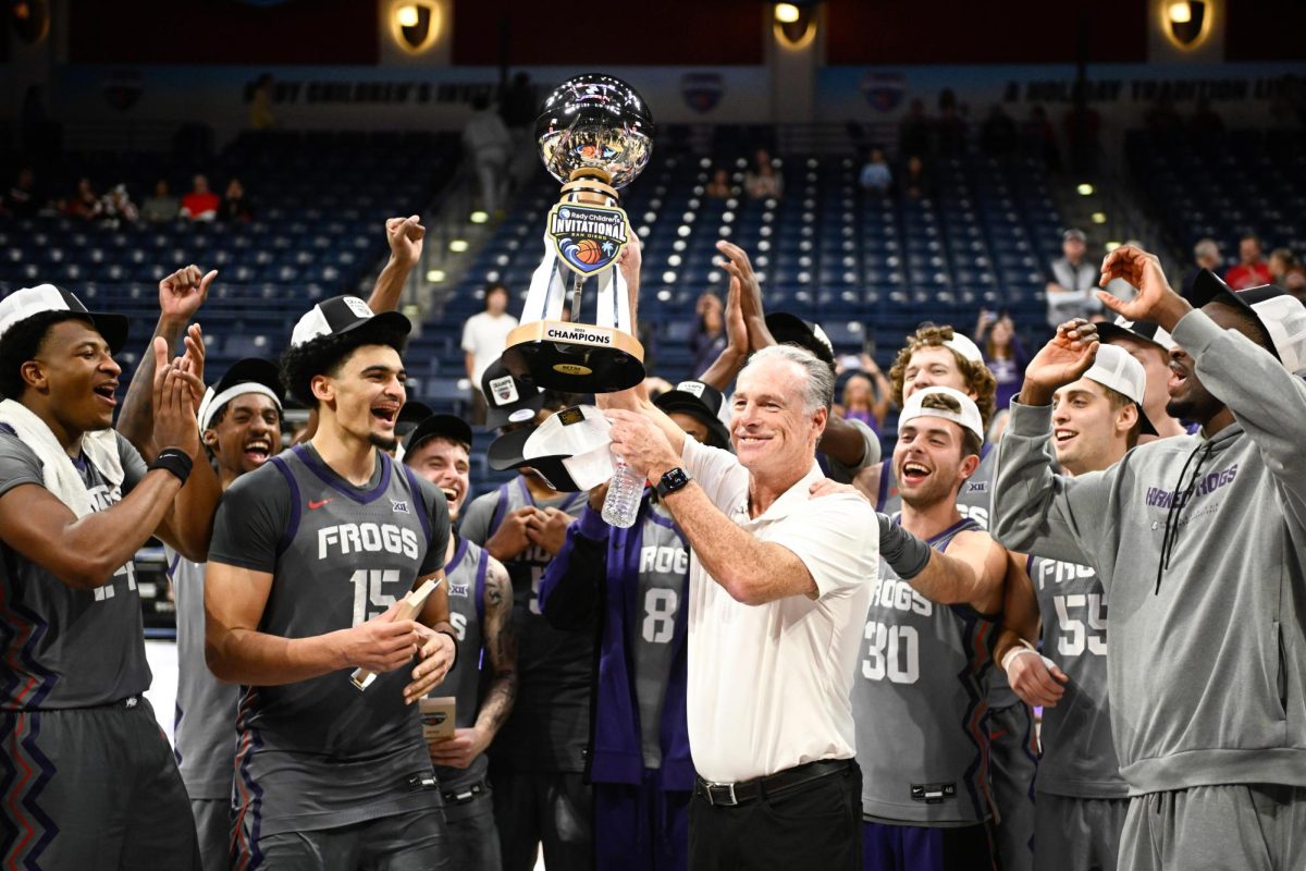 TCU head coach Jamie Dixon, center right, celebrates with the team after they won the Rady Children's Invitational tournament in an NCAA college basketball game against Wisconsin, Friday, Nov. 28, 2025, in San Diego. (AP Photo/Denis Poroy)