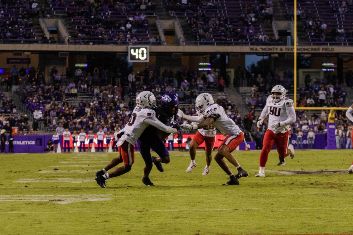 TCU Wide Receiver Eric McAlister is tackled by two Cincinnati defenders at Amon G. Carter Stadium in Fort Worth, Texas, on Nov. 29, 2025. The TCU Horned Frogs defeated the Cincinnati Bearcats 45–23. (TCU360/Nghia Tran)