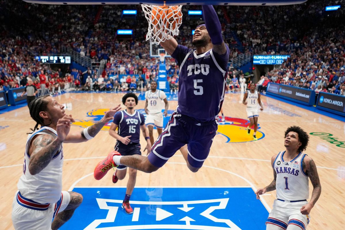 TCU forward Micah Robinson (5) dunks the ball during the second half of an NCAA college basketball game against Kansas, Tuesday, Jan. 6, 2026, in Lawrence, Kan. (AP Photo/Charlie Riedel)